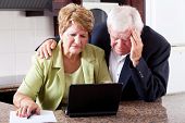 picture of worry  - unhappy senior couple worrying about expenses at home - JPG 