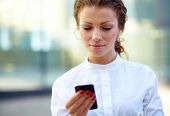 picture of newspaper  - Pretty young business woman with newspaper using mobile phone - JPG 