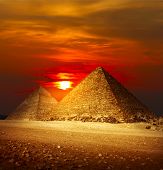 stock photo of sunset  - Pyramids in Giza valley under sunset light - JPG 