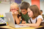stock photo of computer  - Elementary school students looking at computer - JPG 