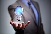 Businessman with illuminated light bulb concept for idea, innovation and inspiration