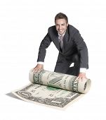 foto of businessmen  - Young happy businessman rolling a big dollar bill - JPG 