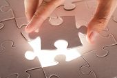 stock photo of puzzle  - hand holding puzzle piece - JPG 