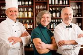 stock photo of restaurant  - Restaurant manager posing with chef cook and waiter wine bar - JPG 