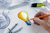Designer drawing a light bulb, concept for brainstorming and inspiration