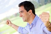 stock photo of excitement  - Excited man celebrating his victory with arms up - JPG 