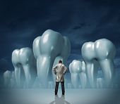 image of health  - Dentist and dental care medical tooth health symbol of oral hygiene with a professional man in a white lab coat facing giant molar teeth on a dark foggy background - JPG 