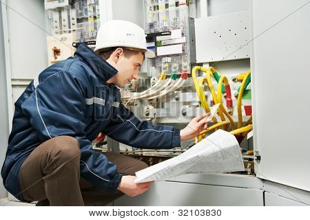 Picture or Photo of Electrician builder at work inspecting cabling connection of high voltage power electric line in industrial distribution fuseboard