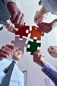 stock photo of puzzle  - Group of business people assembling jigsaw puzzle and represent team support and help concept - JPG 