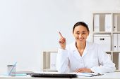 stock photo of medical doctors  - Young female doctor in white uniform at workplace - JPG 