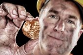 pic of gold  - A gold miner shows a golden nugget freshly excavated from a mine - JPG 