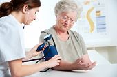 picture of pressure  - Female doctor measuring blood pressure of senior woman - JPG 
