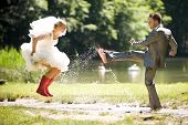 picture of nature  - bride and groom splashing water in the nature trash the dress - JPG 