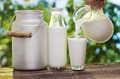 pic of pour  - Pouring milk in the glass on the background of nature - JPG 
