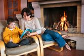 picture of time  - Mother and son reading a book in front of fireplace - JPG 