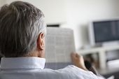picture of newspaper  - Back view of man reading newspaper at home - JPG 