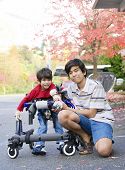 pic of cerebral  - Teen boy with disabled little brother in walker out walking - JPG 