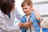 stock photo of medical doctors  - Senior female doctor examining happy child smiling - JPG 