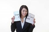 stock photo of debt  - woman holding up a piece of paper with the words credit card debt written on it and tearing the sheet of paper in half - JPG 