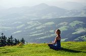 stock photo of outdoor  - Young woman meditating outdoors - JPG 
