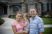 stock photo of home  - A young family proudly stands in front of their new home - JPG 