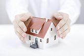 picture of property  - Hands covering a small realistic model home - JPG 