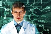stock photo of technology  - Young chemist in white uniform working in laboratory - JPG 