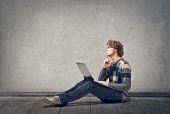 stock photo of man  - young man with laptop sitting on floor - JPG 