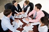 stock photo of meeting  - Businesspeople gathered around the table for a meeting brainstorming - JPG 