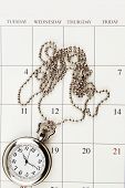 stock photo of watch  - Pocket watch on calendar page - JPG 