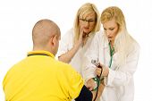 picture of bloodpressure  - medical team with female doctors measuring bloodpressure isolated over a white background - JPG 