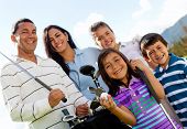 stock photo of golf  - Portrait of a beautiful happy family playing golf - JPG 
