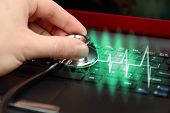 foto of medical doctors  - Male hand with stethoscope over black keyboard of laptop - JPG 
