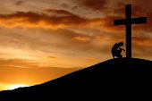 stock photo of religion  - Silhouette of prayer bend to the cross to make a confession - JPG 
