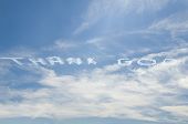 stock photo of blue sky  - Thank God written in the sky by an airplane with blue sky on a partially cloudy day - JPG 