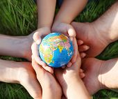 pic of earth  - Earth in hands of the family against green grass blurred background - JPG 