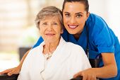 stock photo of health  - happy senior woman on wheelchair with caregiver - JPG 
