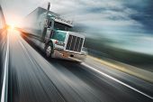 image of industrial  - Big freight truck speeding on freeway at sunset - JPG 