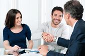 image of meeting  - Happy couple seal a deal with their personal financial advisor at home - JPG 
