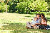 pic of  photo  - Family looking at their photo album in the park - JPG 