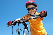 picture of cheerful  - Cheerful little guy in protective sportswear riding a bike - JPG 