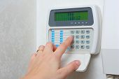 foto of security  - female hand arming a burglar alarm system - JPG 