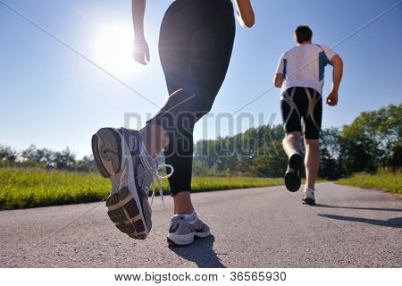 Picture or Photo of Young couple jogging in park at morning. Health and fitness.