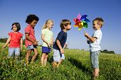 stock photo of children  - Children experiencing  alternative energy by blowing at windmill - JPG 