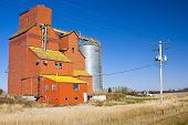 stock photo of blue sky  - Old orange grain elevator on the Canadian priaires in a small town called Conquest - JPG 