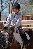 foto of horse  - smiling boy seated on a horse participates in therapy - JPG 