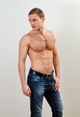 picture of guy  - Young handsome guy in jeans with bare torso against the wall - JPG 