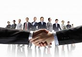 foto of handshake  - business handshake against white background and standing businesspeople - JPG 