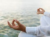 stock photo of soul  - Woman practicing yoga at sunrise near the ocean - JPG 