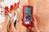 image of wire  - Electrician working with measuring instrument and wires  - JPG 